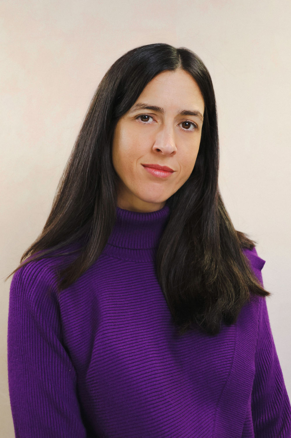 Natural portrait of a woman in a purple jumper against a soft neutral backdrop at a King's Cross London studio.