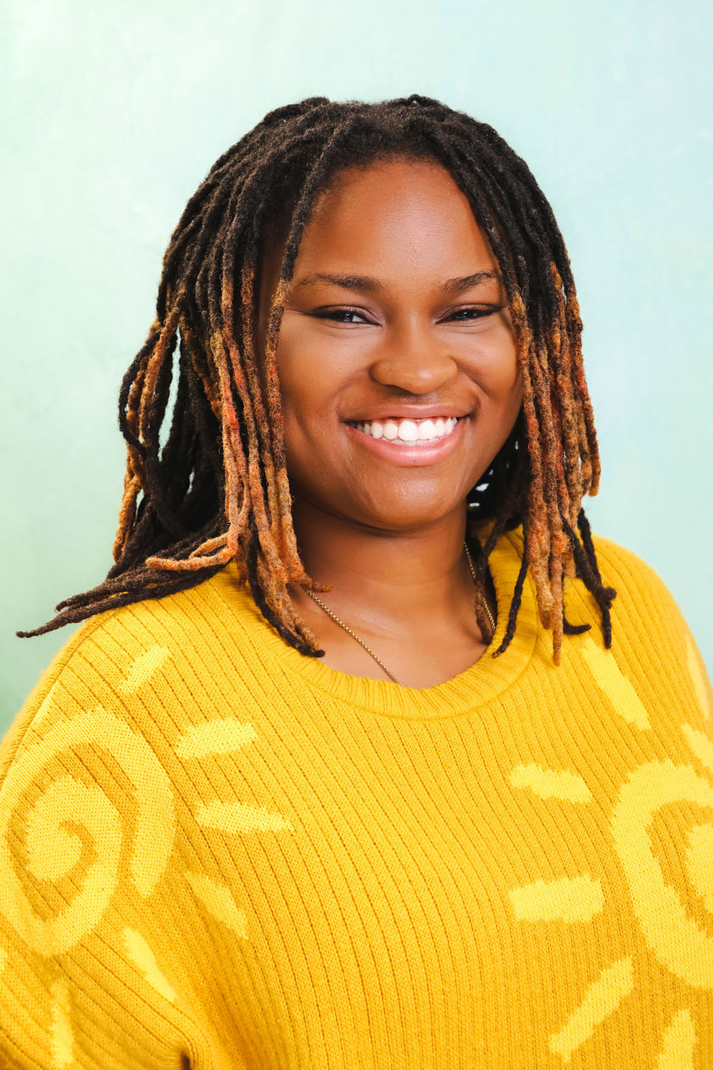 Relaxed personal portrait photographed against a coloured backdrop at the Ceeb Moz studio.