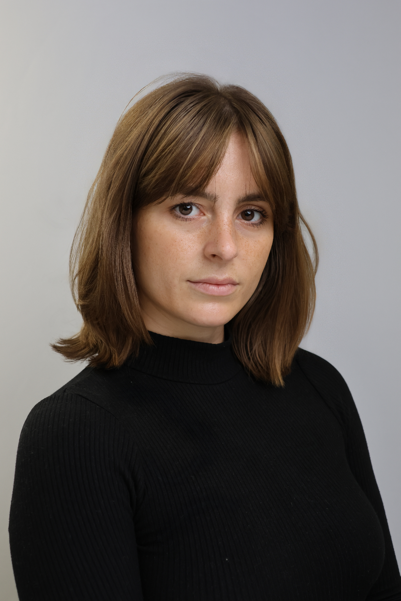 Professional studio headshot with neutral grey backdrop