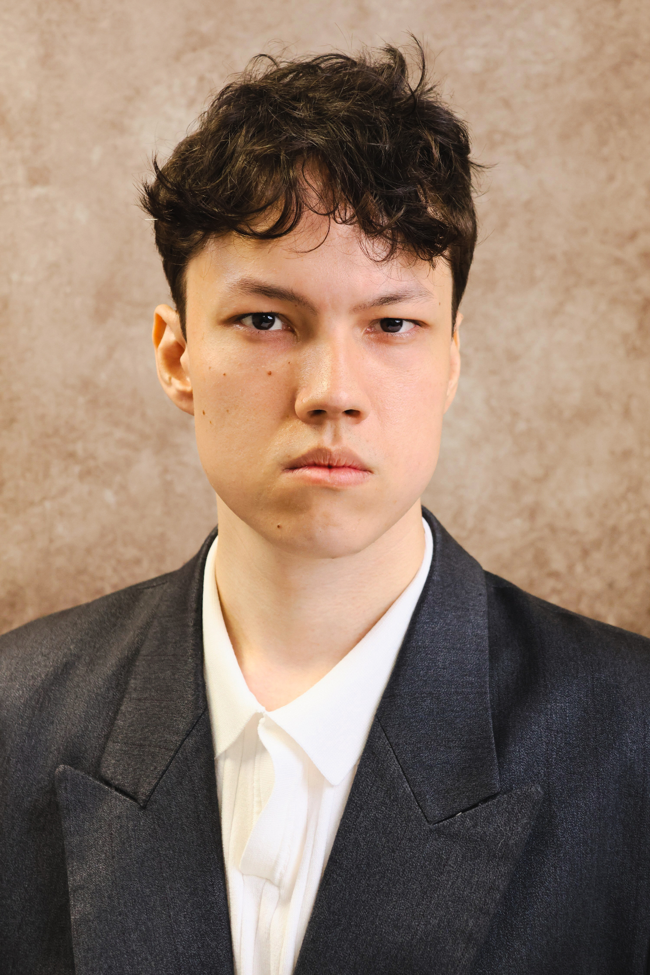 Modern professional male headshot with textured studio backdrop